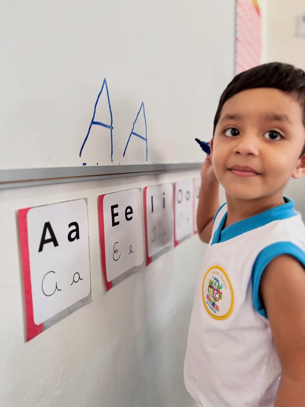 Criança da pré-escola trabalhando a letra A no painel da sala